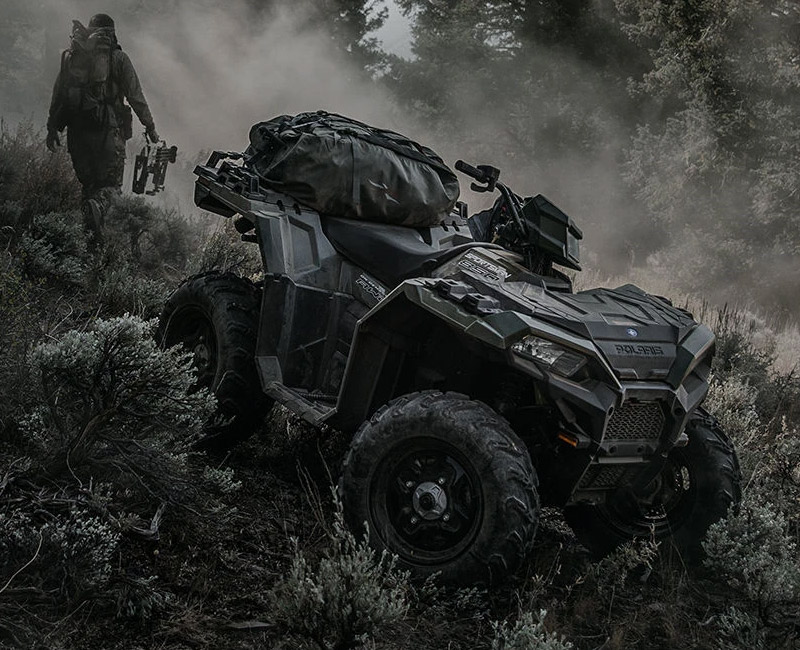 Polaris® Sportsman in the woods going downhill