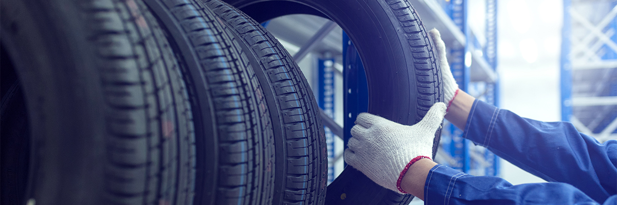 Service tech pulling a tire from a rack